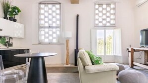 Una sala de estar moderna con una mesa redonda, un sofá y una televisión.