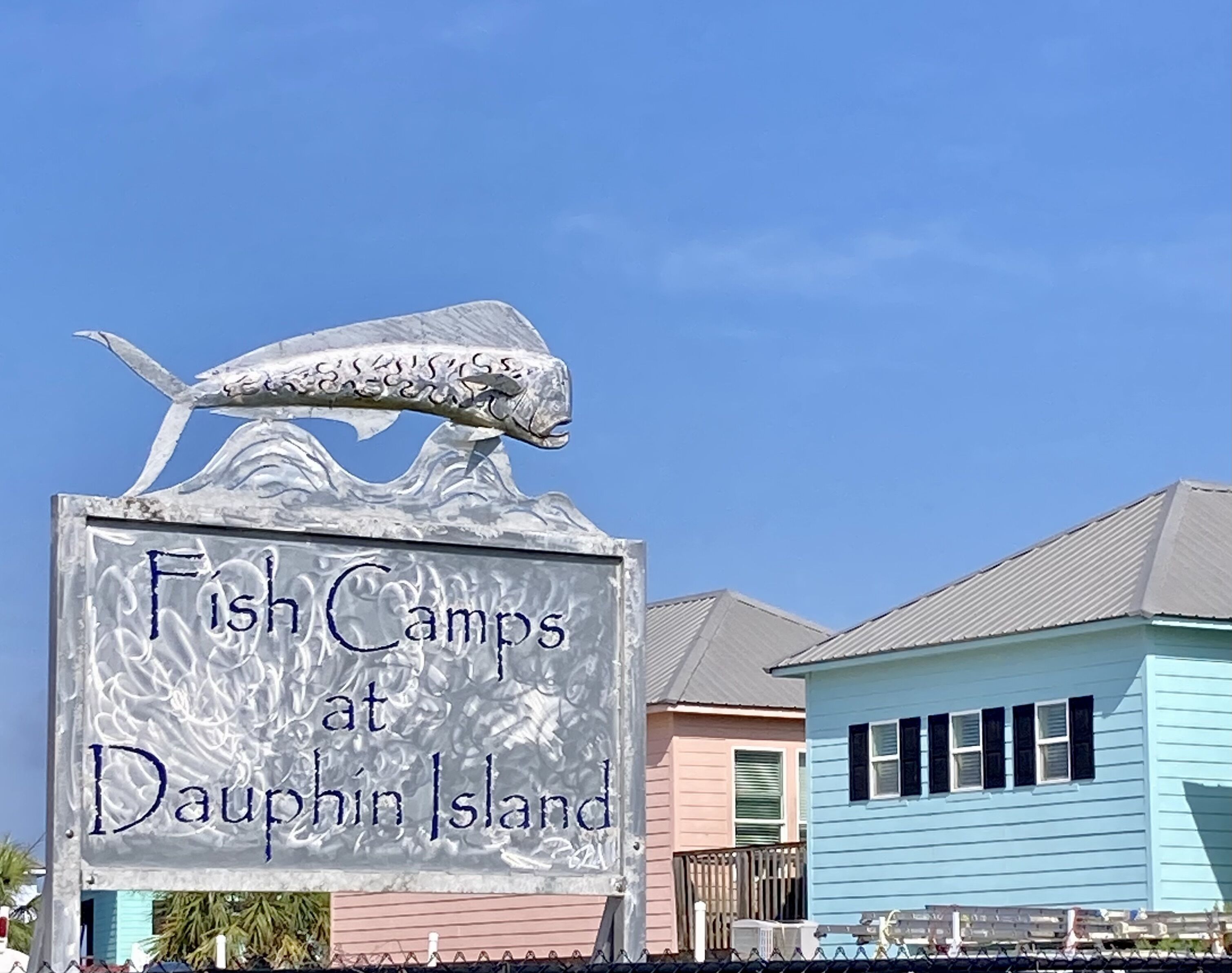 Un panneau indiquant l’emplacement des « Fish Camps » sur l’île Dauphin, avec une sculpture de poisson.