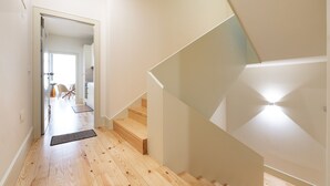 Un intérieur moderne avec un escalier en bois, une cuisine ouverte et un espace repas.