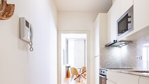Une cuisine moderne avec des armoires blanches, un four à micro-ondes et un plancher en bois.