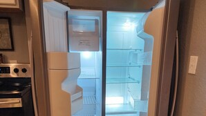 Eine Küche mit integriertem Kühlschrank, Backofen und Mikrowelle.