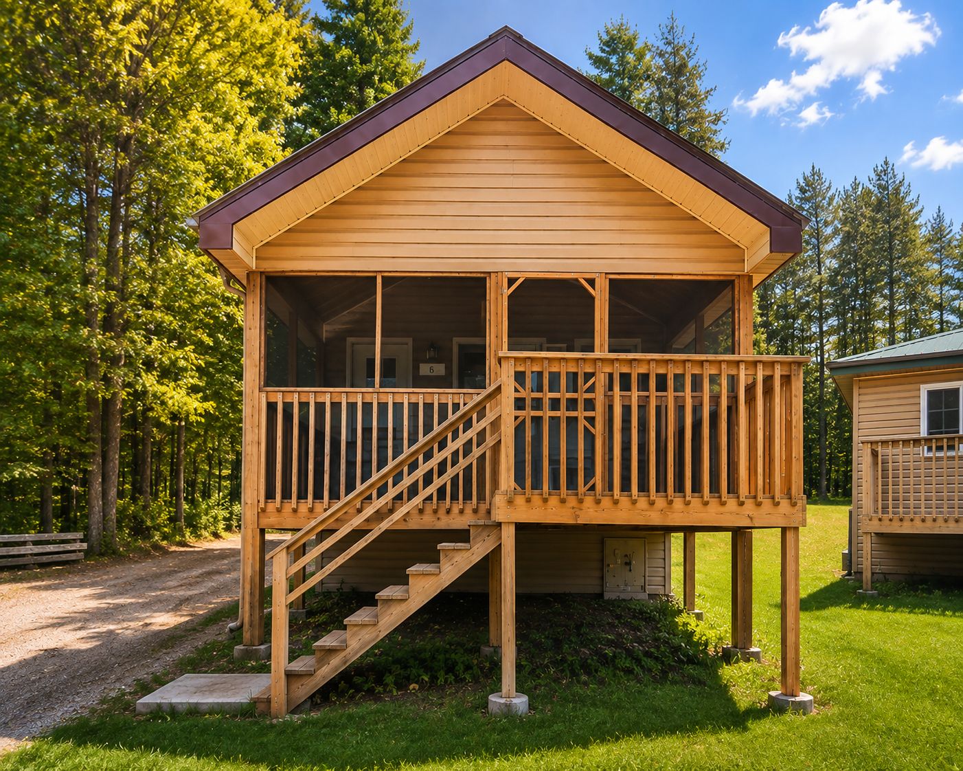 A wooden cabin with a porch and stairs leading to a door.