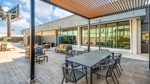 An outdoor patio area with a dining table, chairs, and lounge seating. - Staybridge Suites Dallas Market Ctr Love Field by IHG (Dallas)