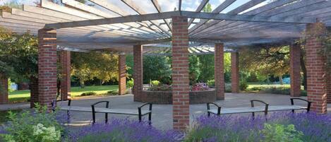 A covered outdoor seating area with brick pillars and a pergola structure.