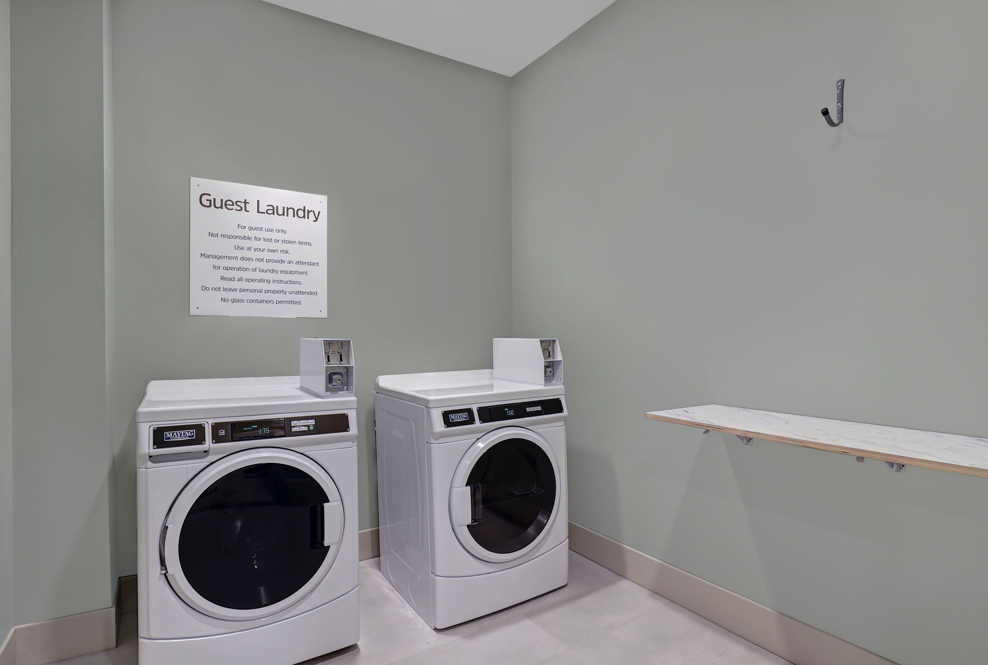 A guest laundry area with two washing machines and a sign indicating it is for guest use only.