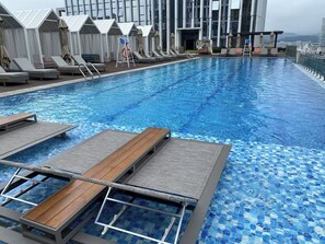 Piscine extérieure en saison, parasols, chaises longues