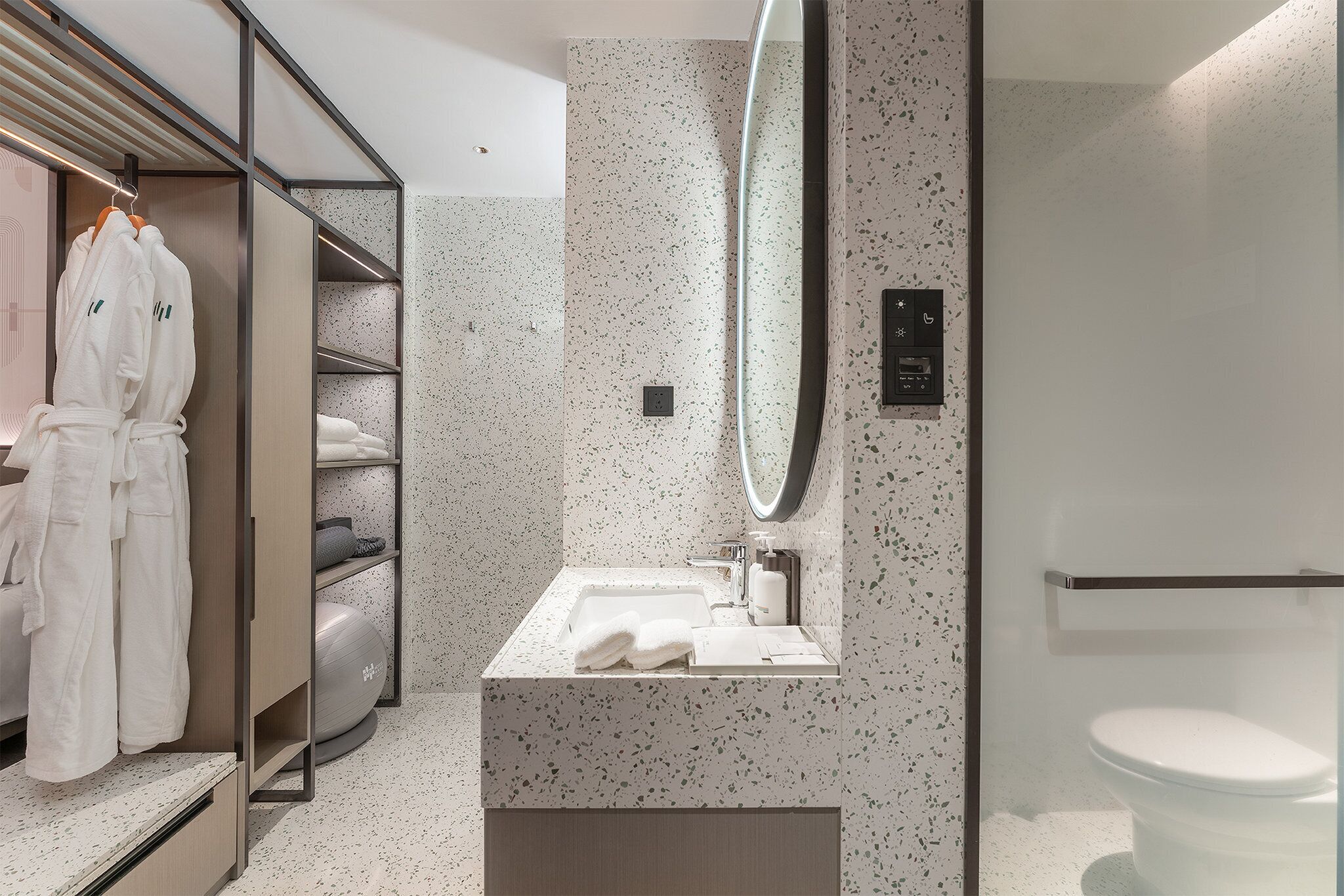 A modern bathroom with a freestanding sink, a large mirror, and a toilet.