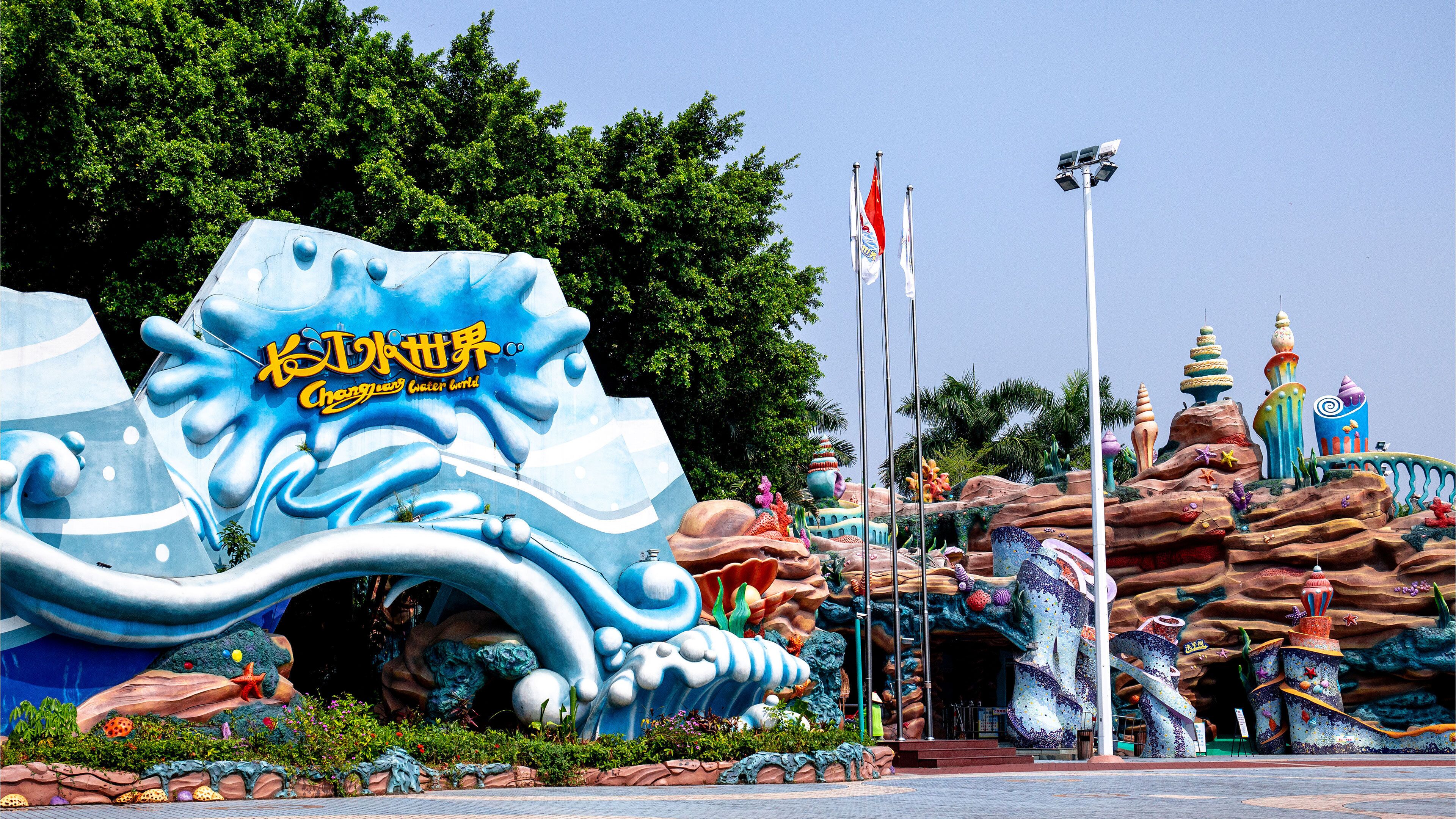 A colorful, whimsical entrance with a large wave sculpture and a sign reading "Chengdu Water World."