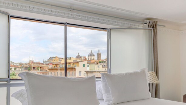 A hotel room with a large window offering a view of historic buildings. - Loft Capocci 37 - Home And More (Roma)