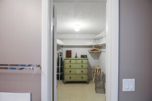 A narrow hallway leading to a room with a green dresser, a radiator, and a shelf with hanging items. - Zen 2/2 home 10 min from Siesta Key - Palm Garden (Sarasota)