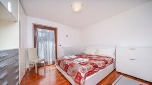 Una camera da letto con un letto, una sedia, una scrivania e un termosifone.