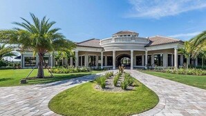 Een groot, twee verdiepingen tellend huis met een cirkelvormig oprit en een verzorgd gazon.