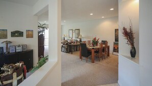 A spacious dining area with a high ceiling, a dining table set for four, and a comfortable seating arrangement.