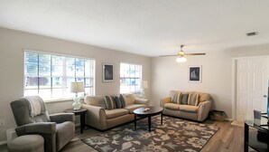 A living room with two sofas, a coffee table, a chair, and a rug. - Delightful 2 BR / 2 BA Home in West Bradenton - Sans Souci (Bradenton)
