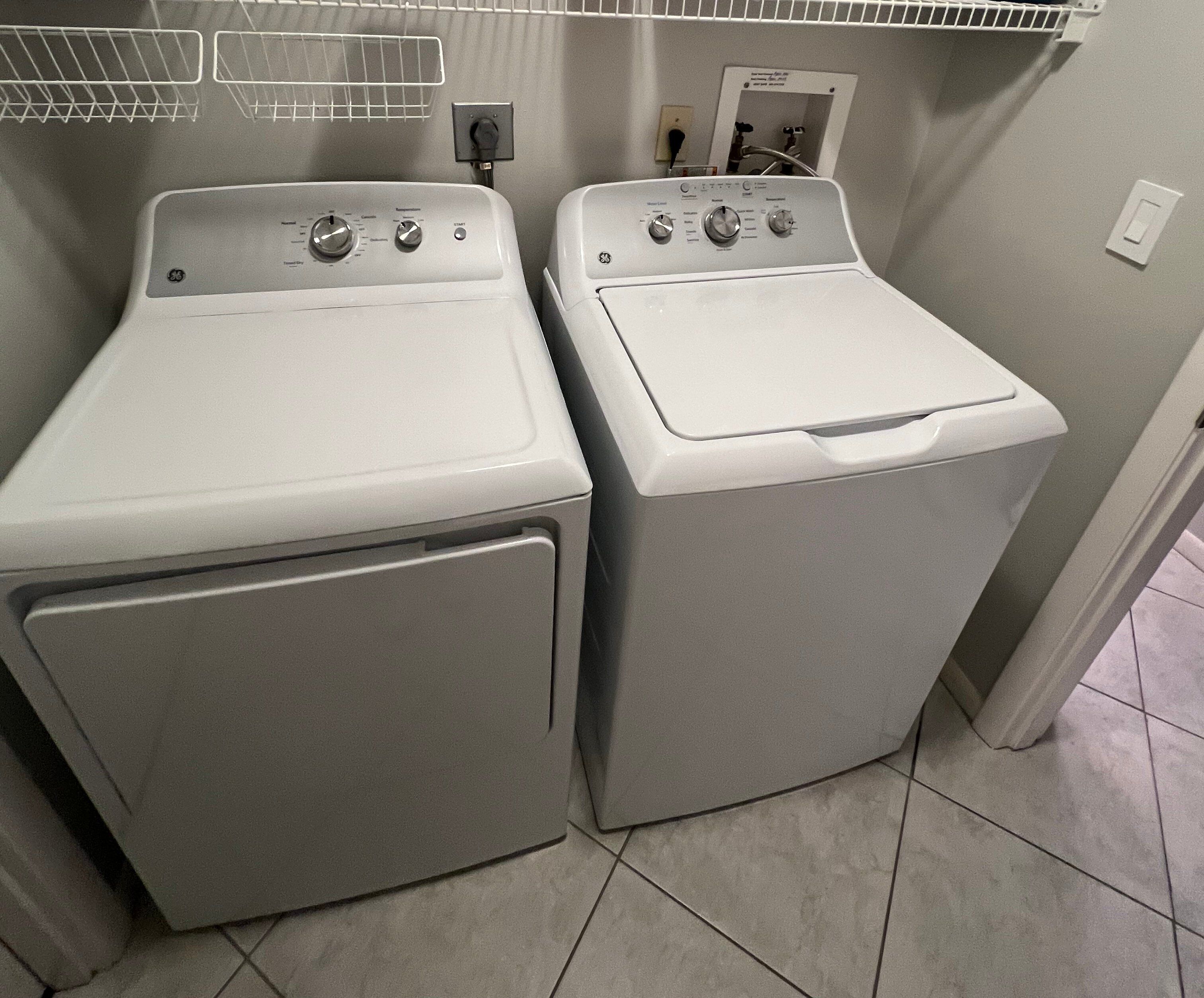 A laundry area with two front-loading washing machines and a utility sink.