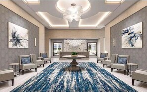 A spacious lobby with a central round table, seating arrangements, and artwork on the walls.