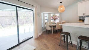 Una cocina moderna con comedor, ventanas amplias y vistas al exterior.