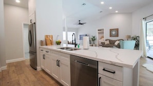 Una cocina moderna con una isla central, electrodomésticos de acero inoxidable y un ventanal amplio.