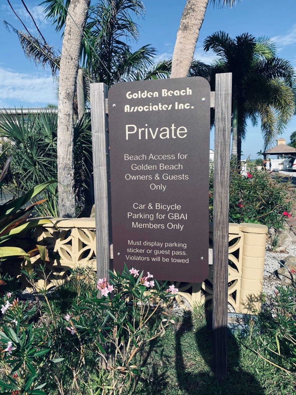 A sign indicating private beach access for Golden Beach Associates Inc. with car and bicycle parking for GBAI members only.