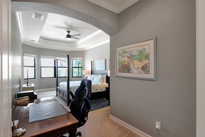 A hotel room with a bed, desk, chair, and a painting on the wall. - Gorgeous lakefront pool home with golf course view Birdie (Lakewood Ranch)