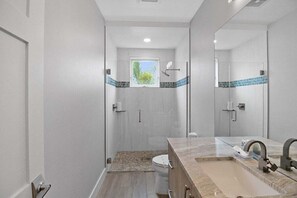 A modern bathroom with a shower, toilet, and sink. - Luxury 4BR Siesta Key villa - Walk to the beach - Beach House Residences Unit 1 (Sarasota)