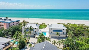 Propiedad frente al mar con varias construcciones, piscina y vista despejada del océano.