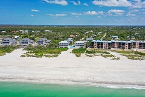 An aerial view of a coastal hotel with multiple buildings, a sandy beach, and a clear view of the ocean. - Secluded gulf-front retreat with stunning ocean views - Sanibel Island - Golden Beach #1 (Sanibel)