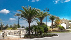 A sign for Lakewood National with palm trees and a building in the background. - Breathtaking 3 BR condo with lake views in Lakewood National Golf Club - Shades Of Summer (Lakewood Ranch)