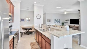 A modern kitchen with granite countertops, wooden cabinets, and a central island.