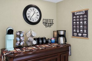 Un espace bar où l’on sert du café, avec une horloge, du matériel pour préparer le café et une affiche présentant un guide sur le café.