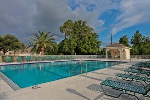 A swimming pool with lounge chairs and a gazebo. - Golf course view - 2BR - 2nd floor condo - Eagle Hunters (Sarasota)