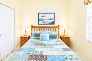 A bedroom with a wooden bed, two bedside tables with lamps, a quilt, and a framed picture on the wall. - Stunning 3BR lakefront - Pool home in Palmetto - Cranes Galore (Palmetto)