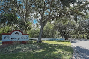 A sign for Regency Oaks with a white fence and trees in the background. - Stunning 3BR lakefront - Pool home in Palmetto - Cranes Galore (Palmetto)