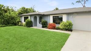 A single-story house with a grey roof, a garage, and a well-maintained lawn. - Relaxing 2BR - Pool home close to attractions - Charlotte's Dream (Port Charlotte)