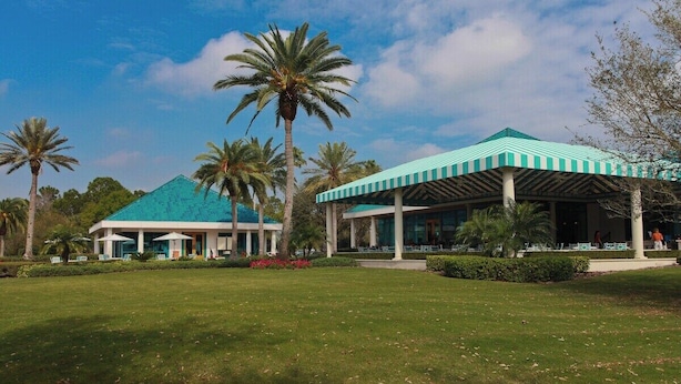 A building with a green roof and a covered outdoor area with columns.