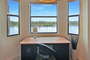 Escritorio en esquina con vista a un lago y árboles.