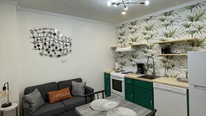 A compact kitchen with a dining area, a modern chandelier, and a wall-mounted art piece. - A  Cozy studio unit in northern Wisconsin (Antigo)