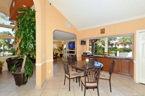 Enjoy meals in this dining area with a large round table and six chairs, offering a view of the outdoors.
