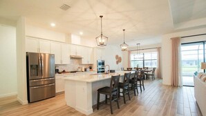 A modern kitchen with a central island, stainless steel appliances, and pendant lighting. - Exquisite waterfront 3BR pool home in Lorraine Lakes - Grand Getaway (Bradenton)