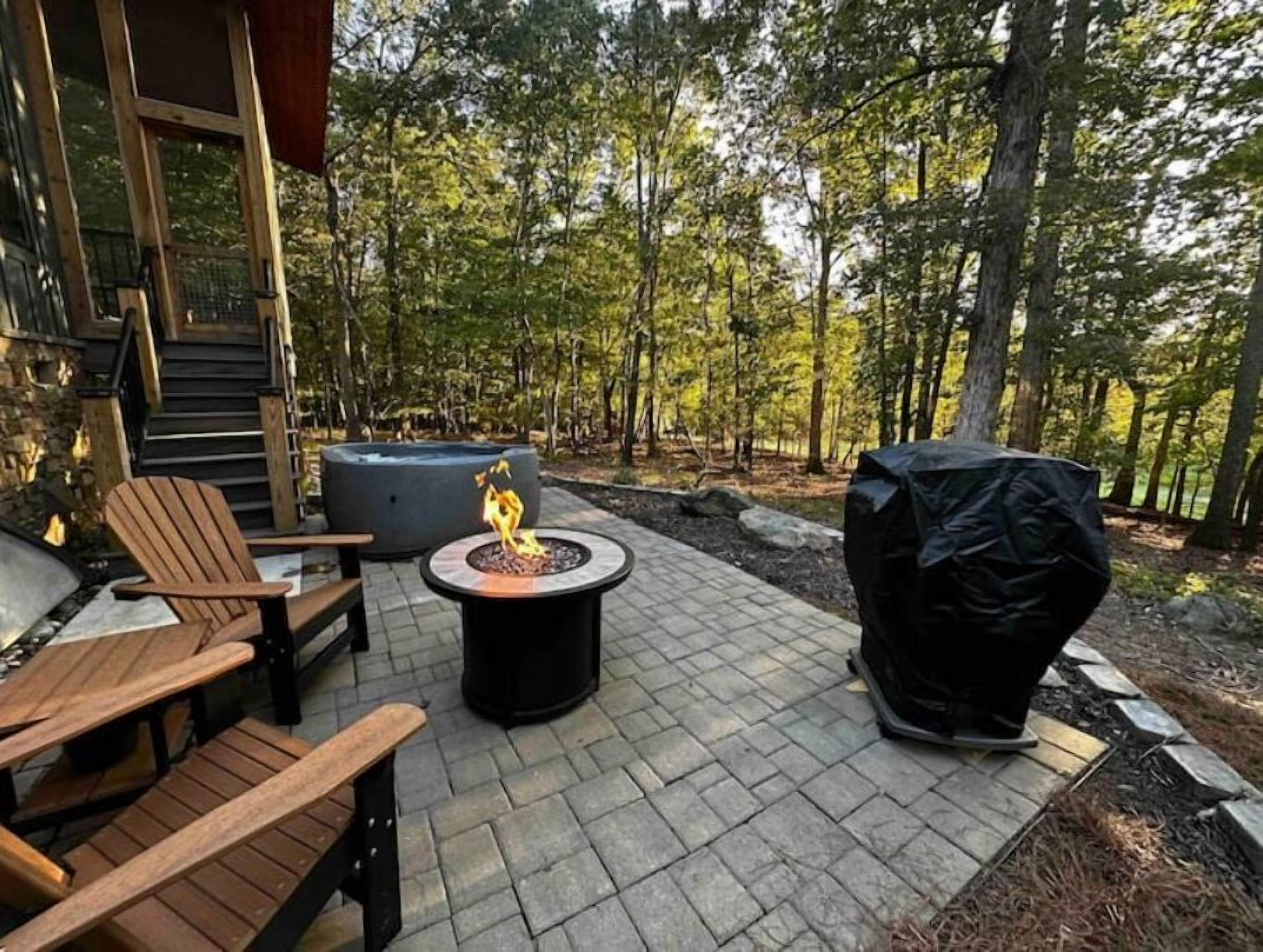 Private patio with fire table, hot tub, and gas grill.