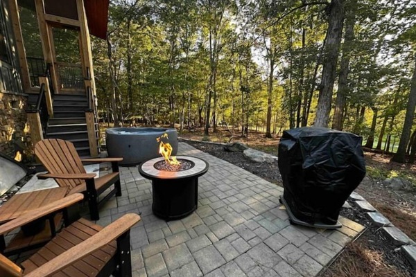 Private patio with fire table, hot tub, and gas grill.