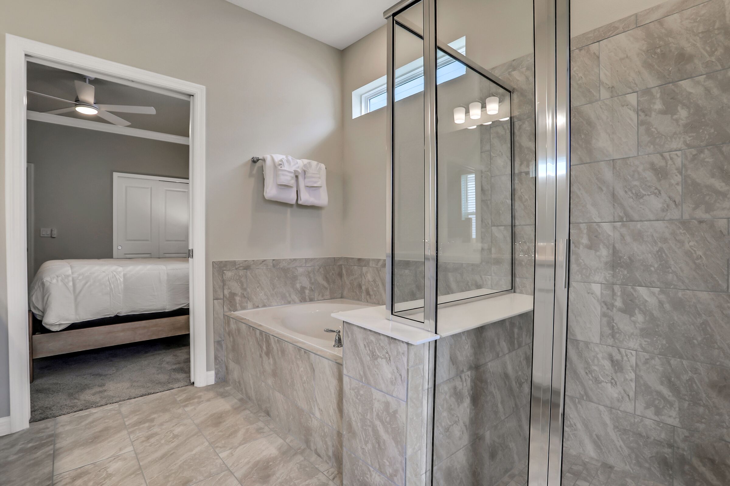 A modern bathroom with a glass-enclosed shower, a bathtub, and a walk-in shower.