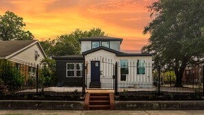 A two-story house with a front porch and a black gate. - Med Center 2BR | Gated, Near NRG, MD Anderson (Houston)