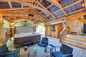 Une cabane en bois dotée d’un bain à remous, d’un espace salon extérieur et d’un escalier menant à une terrasse.