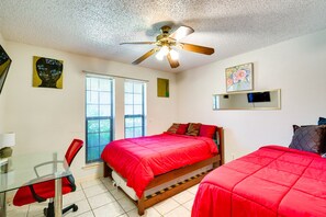 A bedroom with two beds, a ceiling fan, a desk with a chair, and two windows. - Charming Texas Escape, Near Cedar Hill State Park! (Duncanville)