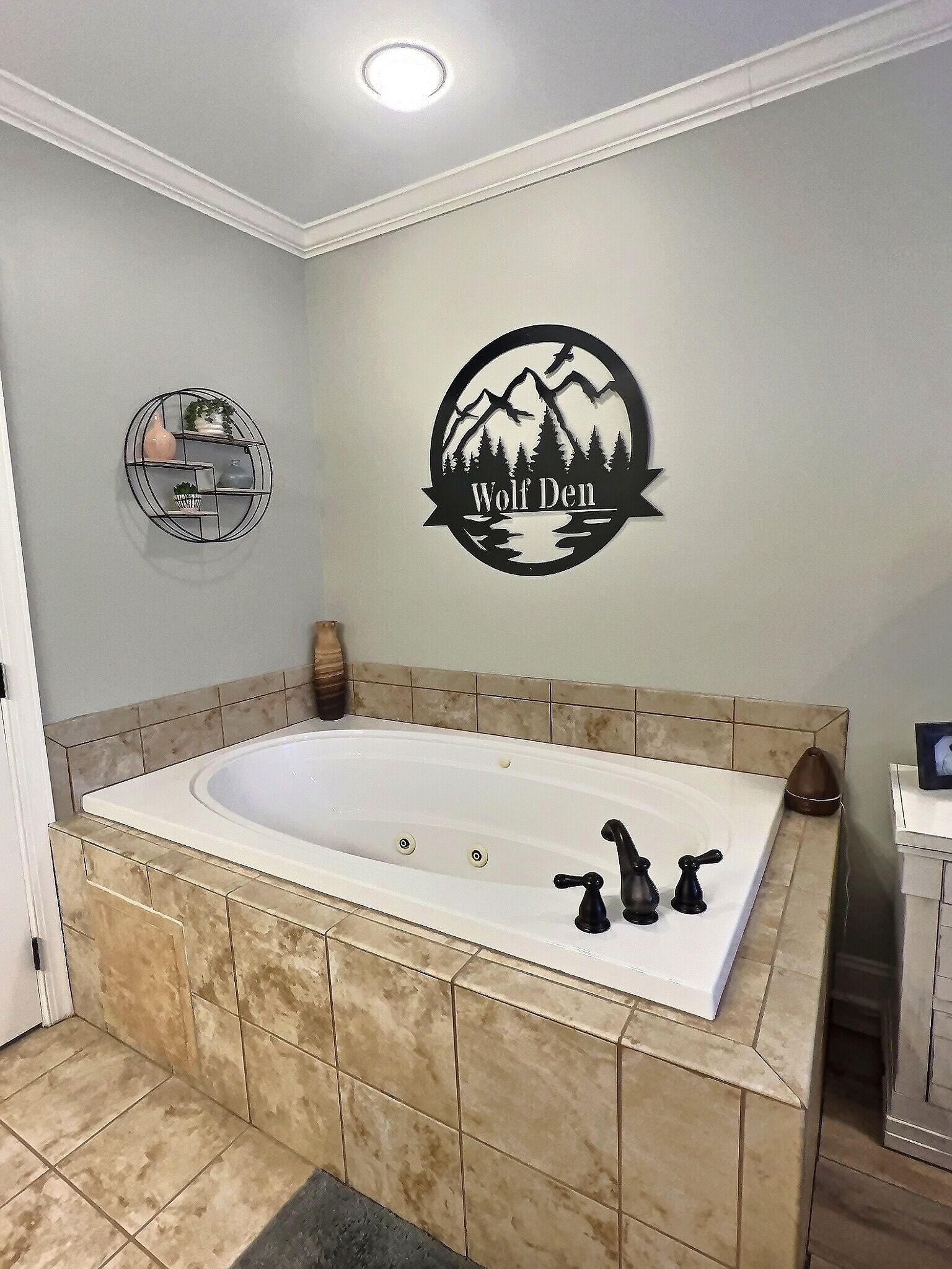 Un baño con una bañera grande, un perchero de pared y un adhesivo decorativo.
