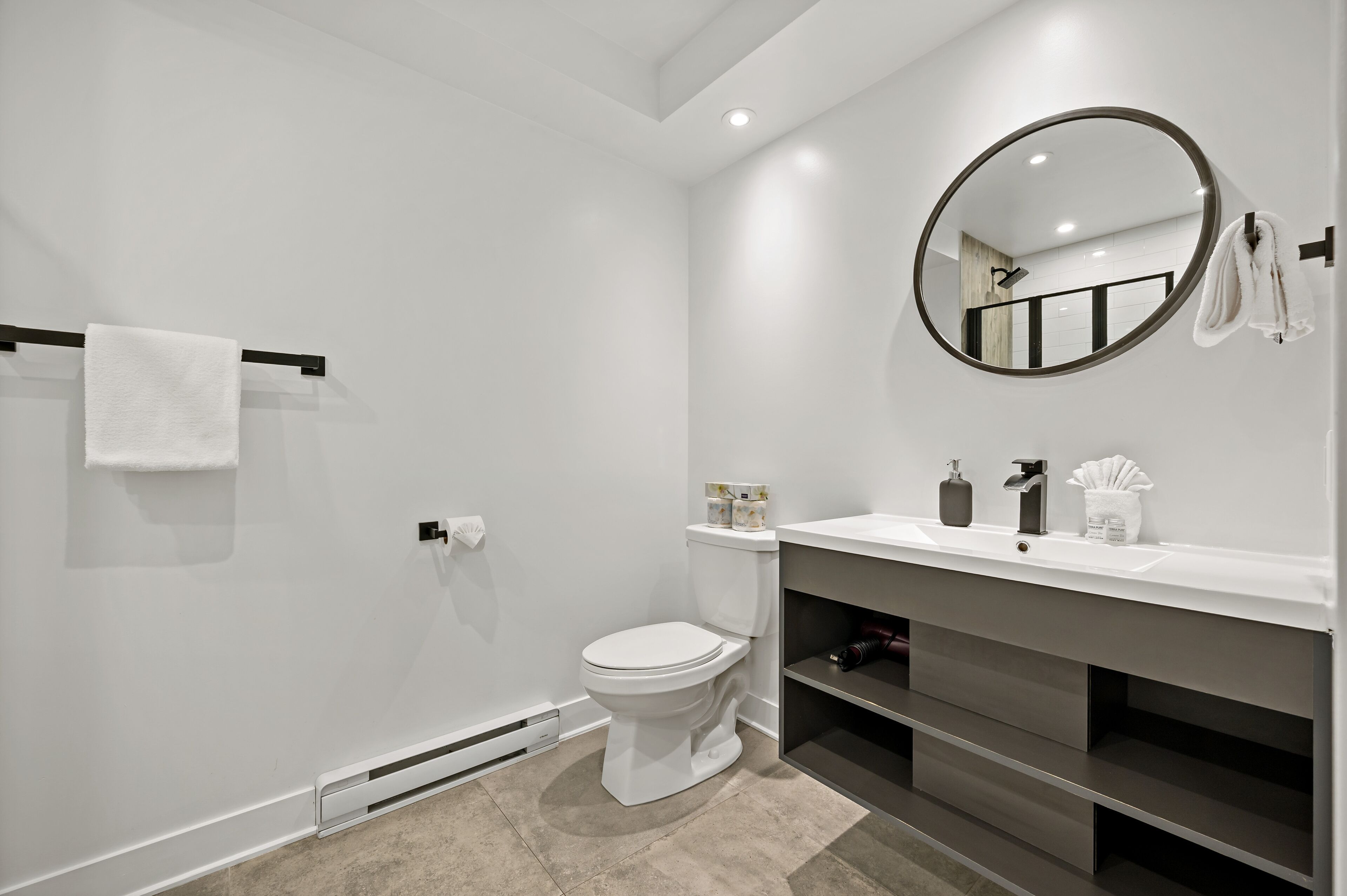 Et moderne badeværelse med toilet, vask og spejl.