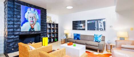 Een woonkamer met een stenen openhaard, rieten meubels, een bank en een salontafel.