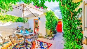 An outdoor patio with a table and chairs, a grill, and a colorful rug. - Perfect 4 Families, Amazing Reviews Pool & Jacuzzi (Palm Springs)