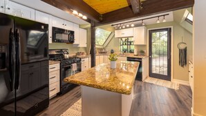 A modern kitchen with a central island, stainless steel appliances, and a view to the outdoors. - Beautiful Unique home with yoga/meditation studio! (Sedona)